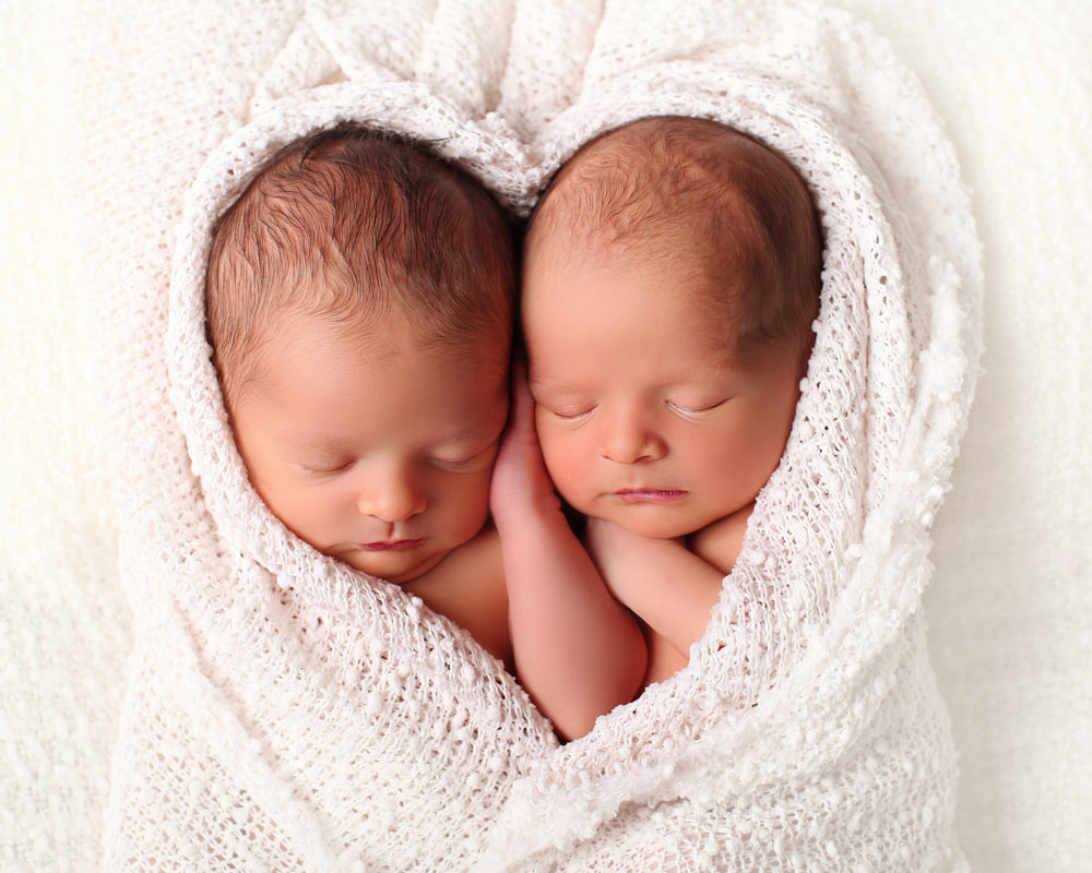 baby twins sleeping in heart-shaped blanket